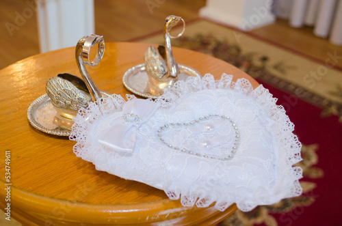 Pink flowers and two golden wedding rings on white background.