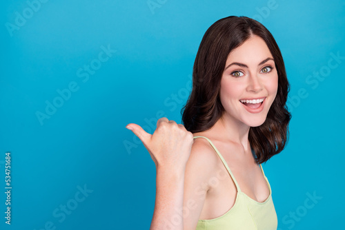 Profile photo of positive pretty lady direct thumb finger empty space isolated on blue color background