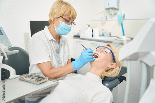 Doctor dentist in a protective mask works in his office