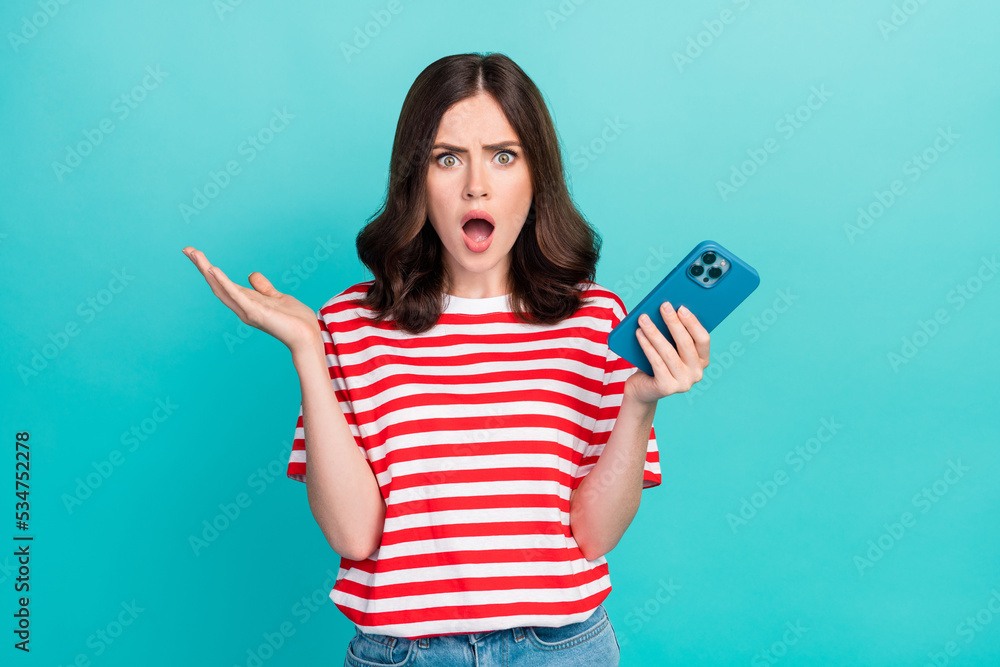 Photo of amazed surprised girl dressed red t-shirt getting message modern gadget isolated teal color background Photo of amazed surprised girl dressed red t-shirt getting message modern gadget isolated teal color background