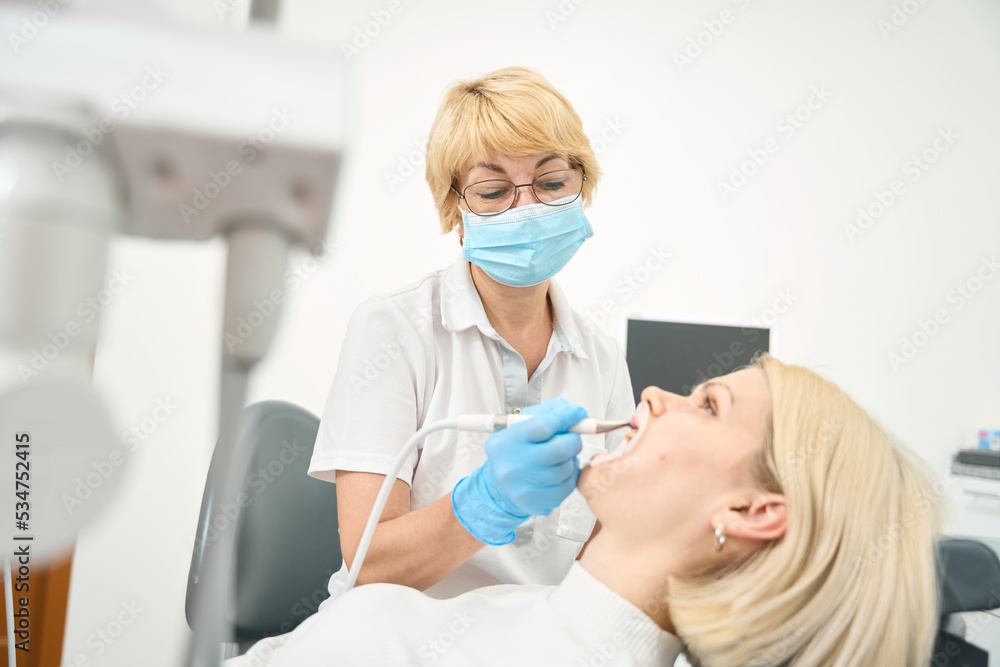Dentist with short white hair at work Dentist with short white hair at work