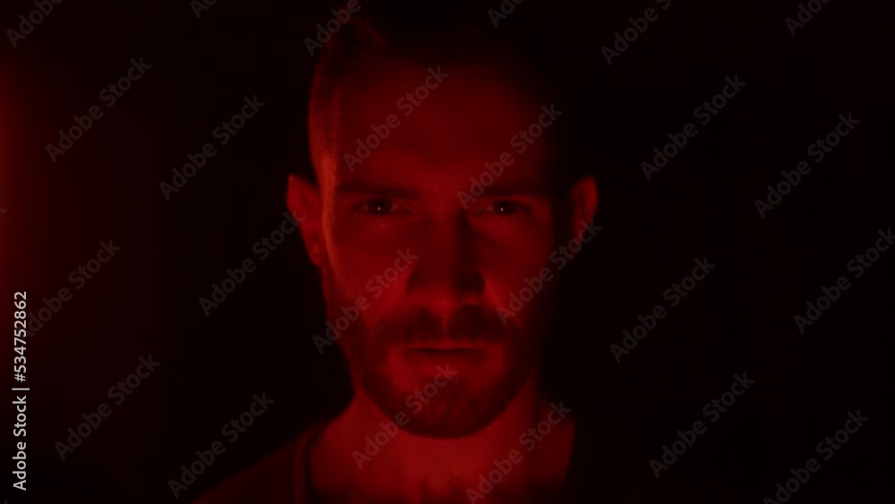 Angry man open eyes, awakes in hell, looking at camera with fury, rage, his face lit with fire flames, grief, sorrow. Male starring at enemy on war with aggresive emotions, insane devilish look. Angry man open eyes, awakes in hell, looking at camera with fury, rage, his face lit with fire flames, grief, sorrow. Male starring at enemy on war with aggresive emotions, insane devilish look.