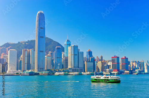 View of Victoria Harbor and Hong Kong skyline on a sunny day.