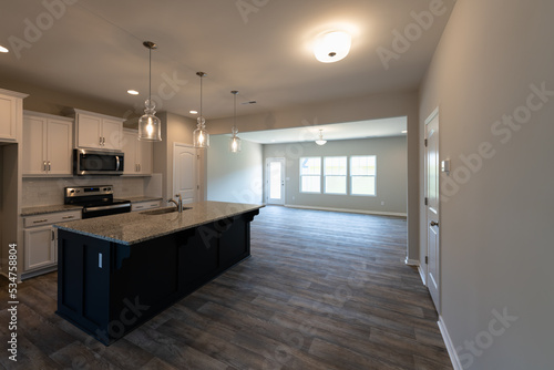 Empty modern townhouse floor showcasing a kitchen with living and dinning room ready to be moved in. Investment  renting  or house ownership concept.