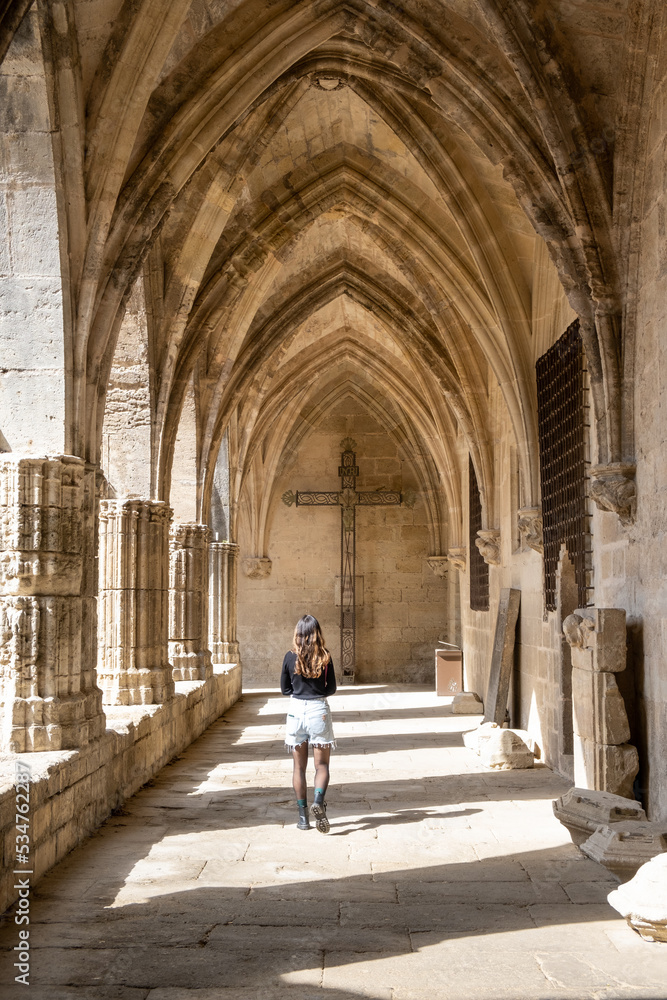 Béziers Cathedral or.Cathédrale Saint-Nazaire-et-Saint-Celse de Béziers, Hérault, Occitanie, South France. Woman in a internal corridor looking to the cross