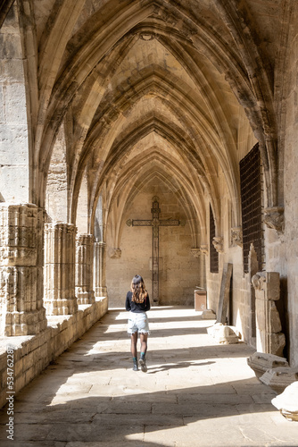 Béziers Cathedral or.Cathédrale Saint-Nazaire-et-Saint-Celse de Béziers, Hérault, Occitanie, South France. Woman in a internal corridor looking to the cross © Otávio Pires