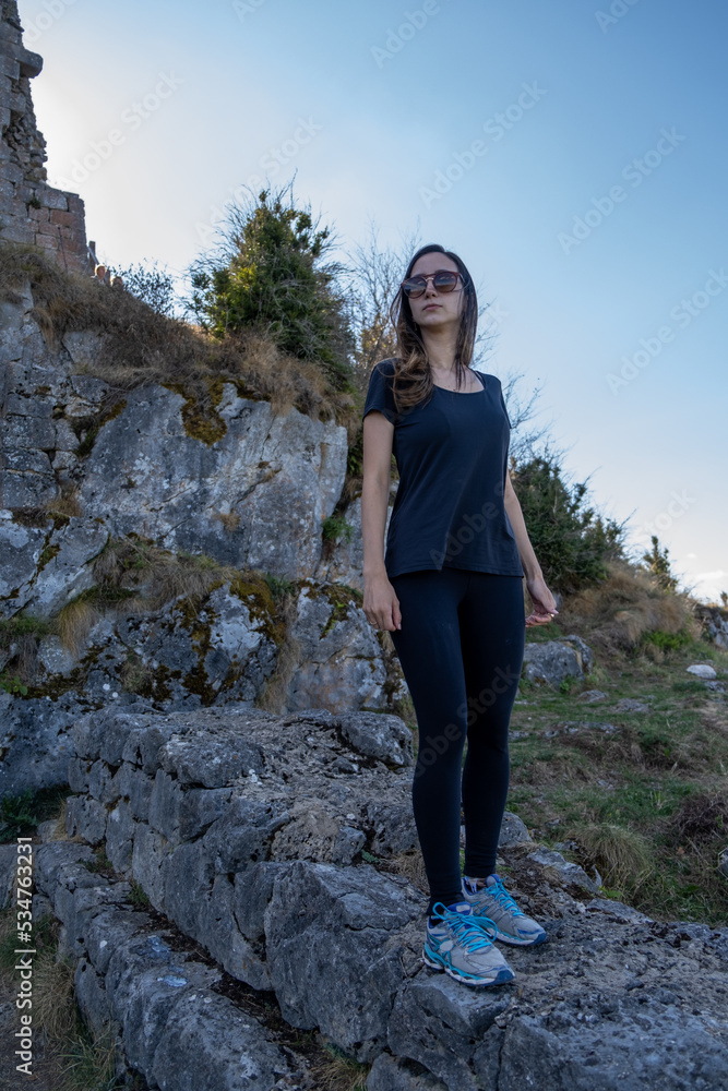 Naklejka premium Young woman looking to the horizon from the ruines of the Montsegur castle in France. Achievement concept
