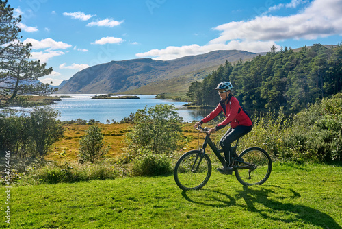 nice senior woman on mountain bike  cycling at Lough Beagh in the Glenveagh National park  near Churchill  Donegal  northern Republic of Ireland