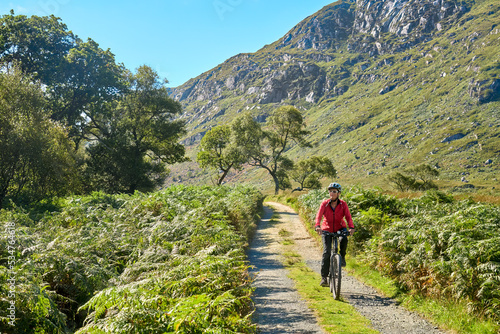 nice senior woman on mountain bike  cycling at Lough Beagh in the Glenveagh National park  near Churchill  Donegal  northern Republic of Ireland