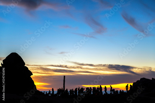 Eine Gruppe von Aussteigern feiern am Strand der sardischen Halbinsel Capo Testa beim Sonnenuntergang