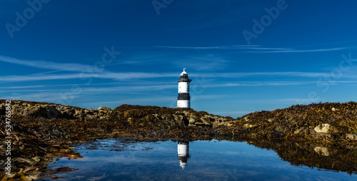 panorama view of the Penmon Lighthouse in North Wales with relfections in a tidal pool photo