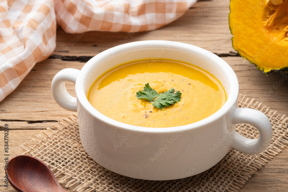 pumpkin carrot cream soup in white bowl,garnished with parsley.Healthy food pumpkin carrot cream soup in white bowl,garnished with parsley.Healthy food
