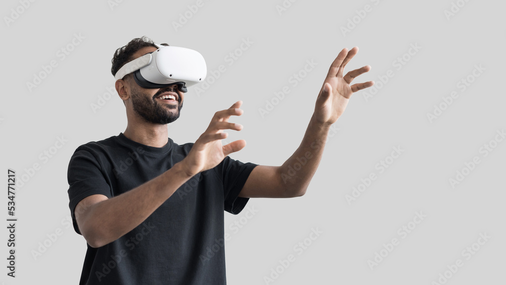 Young man using virtual reality headset isolated on gray background, VR, future gadgets, technology, virtual event, education, study, learning, video game concept Young man using virtual reality headset isolated on gray background, VR, future gadgets, technology, virtual event, education, study, learning, video game concept