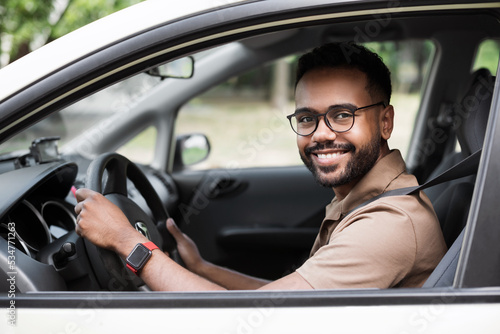 Smiling young man driving a car. Behind the wheel, transportation, car rental, credit, buying a car, modern lifestyle, business concept