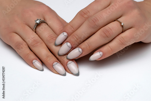 Wedding manicure. Shimmering silver long pointed nails. Close-up on a white background.