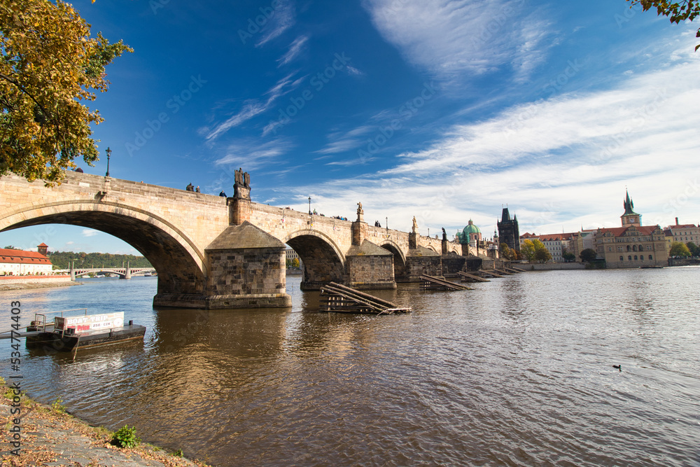 Look over Vltava river to Charles Bridge from embankment in autumn. Prague, Czech Republic.