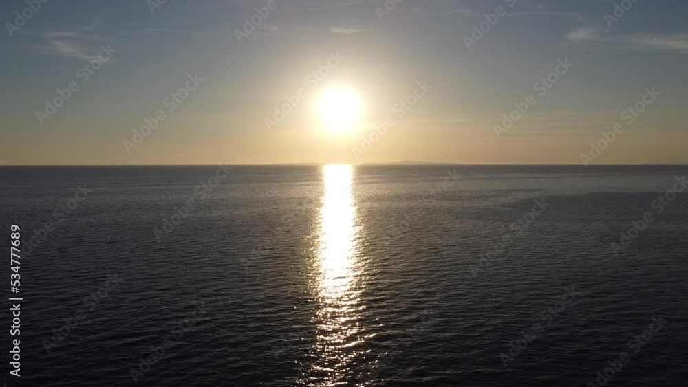 A beautiful sunset that spreads its rays on the calm surface of the ocean A beautiful sunset that spreads its rays on the calm surface of the ocean