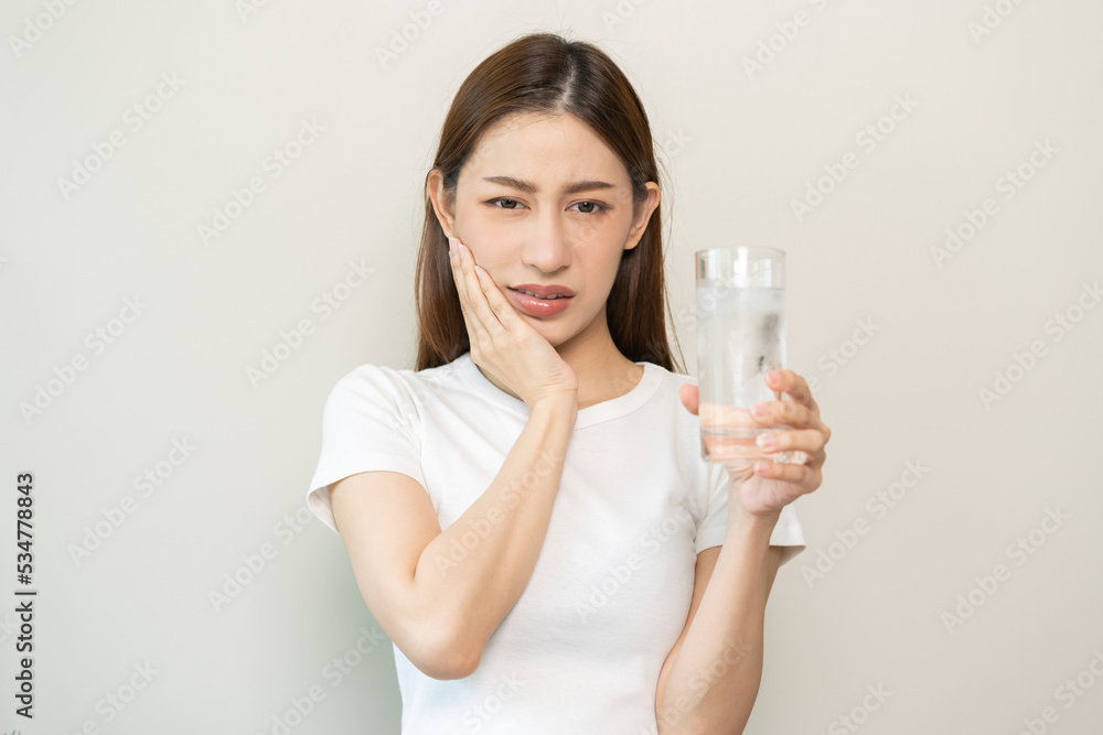 Suffering from toothache, asian young woman, girl touch cheek, face expression ache or feel pain, sensitive molar teeth, hand holding glass of water with ice, inflammation when drink cold, healthcare. Suffering from toothache, asian young woman, girl touch cheek, face expression ache or feel pain, sensitive molar teeth, hand holding glass of water with ice, inflammation when drink cold, healthcare.