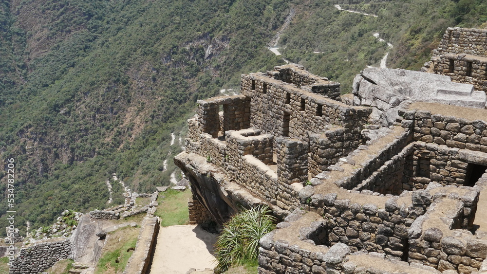 La cité d'Inca Machu Picchu sur le haut d'une montagne, avec ses hautes montagnes voisines, son environnement vertigineux, ses murs de pierre bien polis, son jardin naturel et sa construction histoire