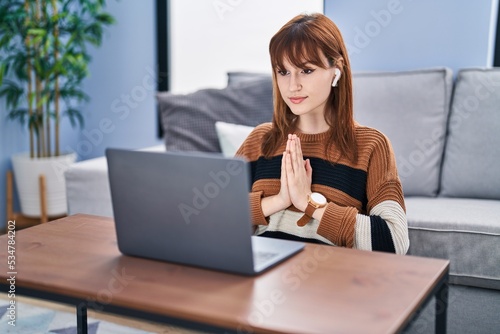 Young woman having online yoga exercise at home