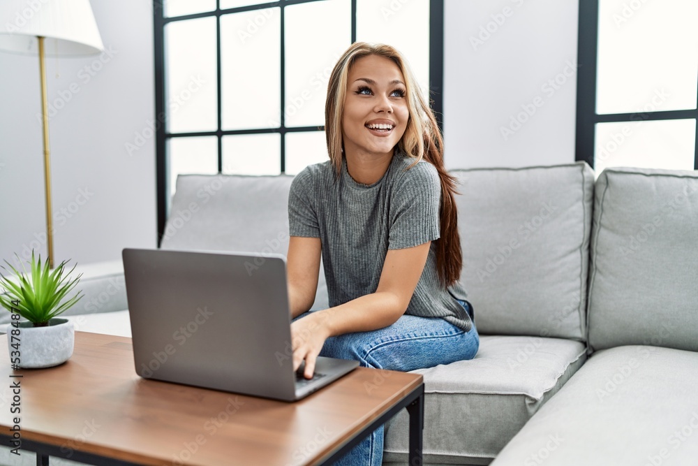 Young caucasian girl using laptop sitting on the sofa at home. Young caucasian girl using laptop sitting on the sofa at home.
