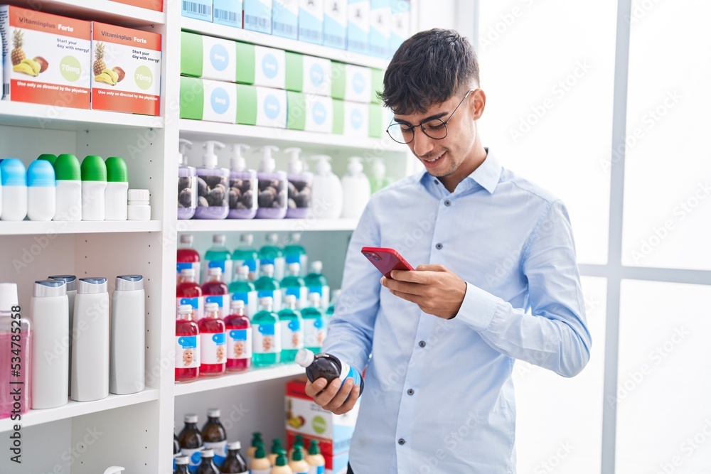 Young hispanic man customer make phot by smartphone to medicine bottle at street