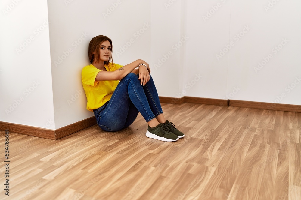 Young woman unhappy sitting on floor at empty room Young woman unhappy sitting on floor at empty room