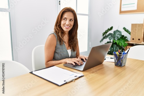 Young latin woman business worker using laptop working at office