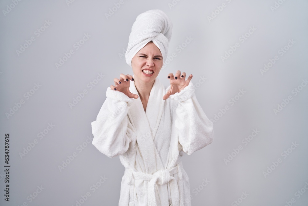 Blonde caucasian woman wearing bathrobe smiling funny doing claw gesture as cat, aggressive and sexy expression Blonde caucasian woman wearing bathrobe smiling funny doing claw gesture as cat, aggressive and sexy expression