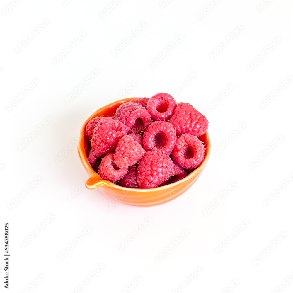 Small bowl of fresh organic raspberries isolated on white background. Cooking ingredient. Small bowl of fresh organic raspberries isolated on white background. Cooking ingredient.