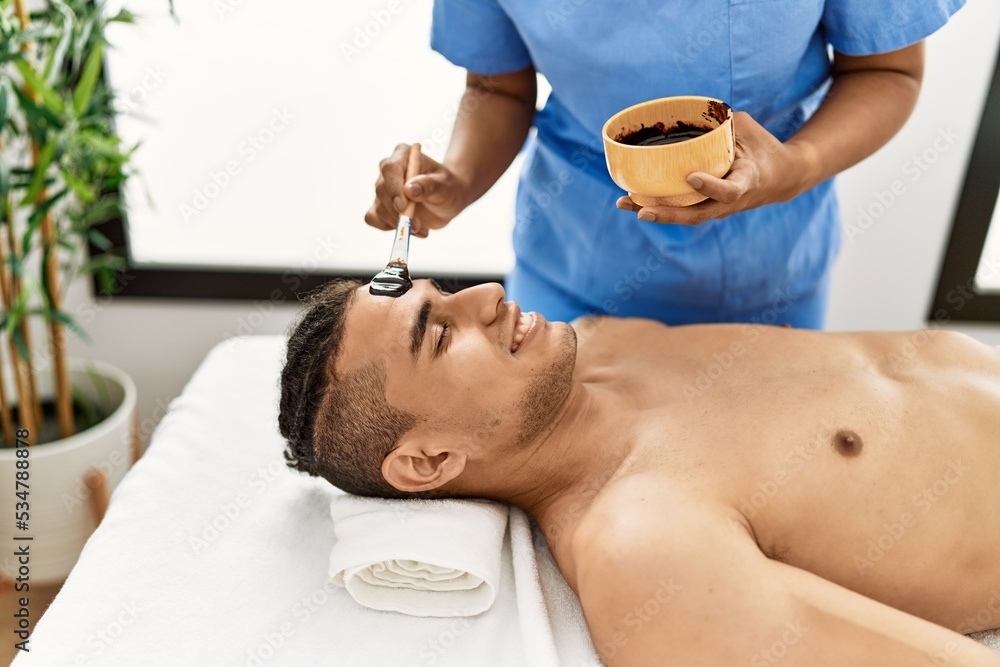 Latin man smiling happy reciving facial treatment at beauty center. Latin man smiling happy reciving facial treatment at beauty center.