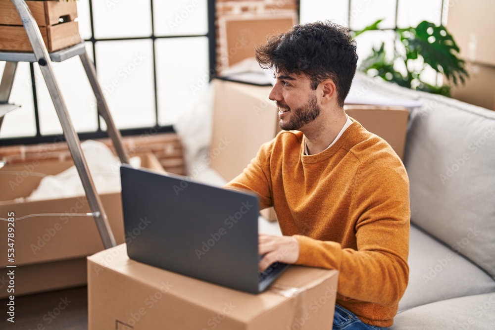 Young hispanic man smiling confident using laptop at new home Young hispanic man smiling confident using laptop at new home