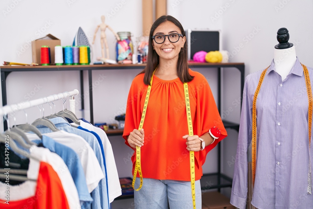 Young beautiful hispanic woman tailor smiling confident standing at tailor shop