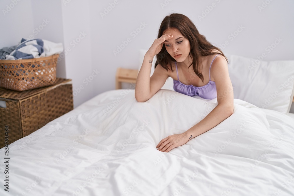 Young woman stressed sitting on bed at bedroom Young woman stressed sitting on bed at bedroom