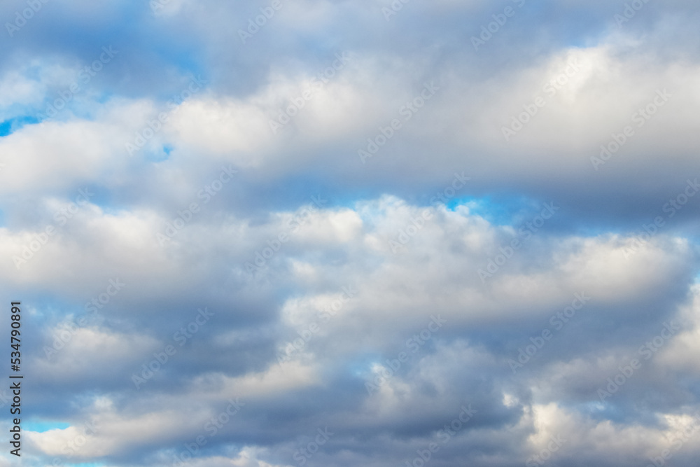 White fluffy clouds densely cover the blue sky White fluffy clouds densely cover the blue sky