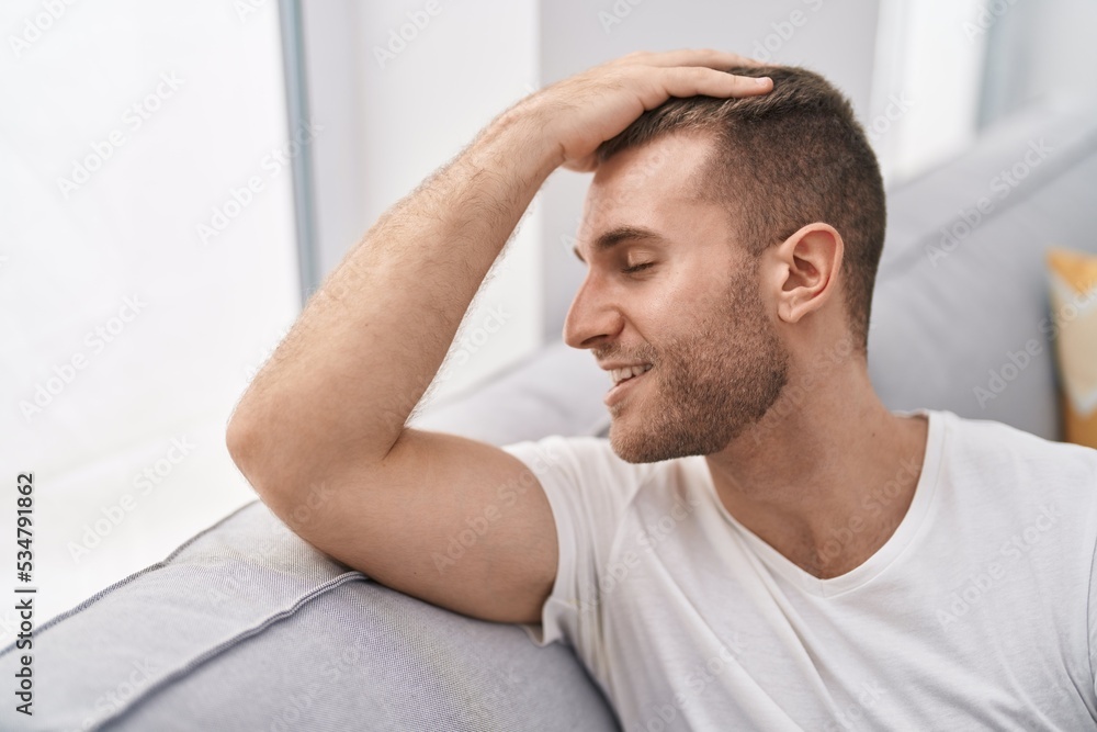 © Krakenimages.com - Young caucasian man smiling confident sitting on sofa at home © Krakenimages.com - Young caucasian man smiling confident sitting on sofa at home