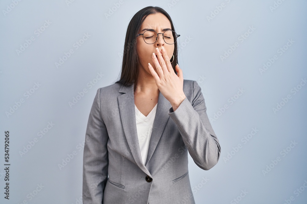 Hispanic business woman wearing glasses bored yawning tired covering mouth with hand. restless and sleepiness. Hispanic business woman wearing glasses bored yawning tired covering mouth with hand. restless and sleepiness.