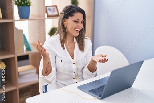 Young hispanic woman smiling confident having video call at home photo