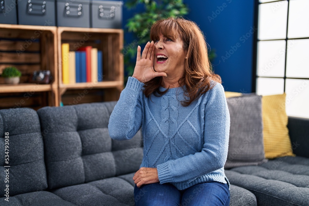 Middle age hispanic woman sitting on the sofa at home clueless and confused with open arms, no idea and doubtful face. Middle age hispanic woman sitting on the sofa at home clueless and confused with open arms, no idea and doubtful face.