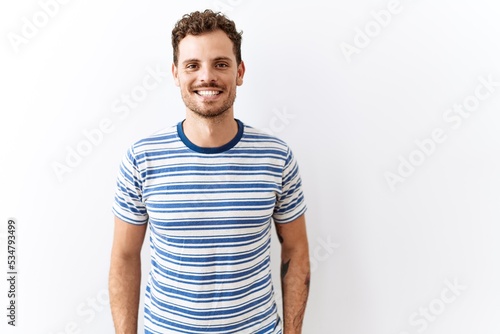 Handsome young man standing over isolated background with a happy and cool smile on face. lucky person.
