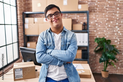 Down syndrome man ecommerce business worker standing with arms crossed gesture at office