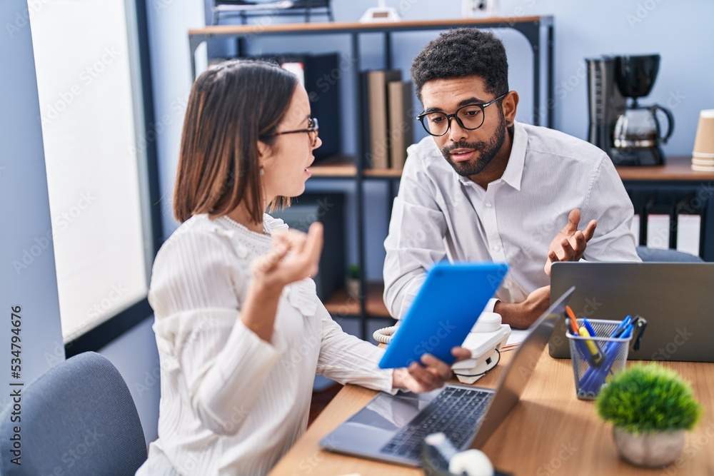 Fototapeta premium Man and woman business workers using laptop and touchpad at office