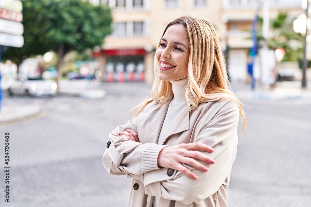 Fototapeta premium Young blonde woman standing with arms crossed gesture at street