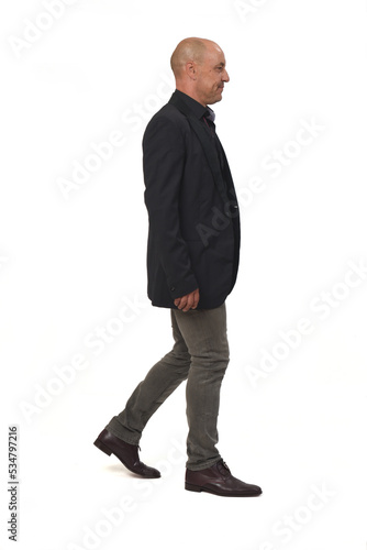  side view of a man with blazer and jeans walking on white background,