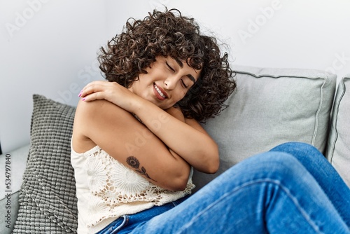 Young middle east woman smiling confident hugging himself at home