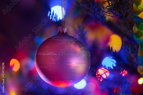 Kolorowa bąbka choinkowa otoczone kręgami ozdobnych świateł. Boże Narodzenie, Wigilia, choinka, prezenty.
