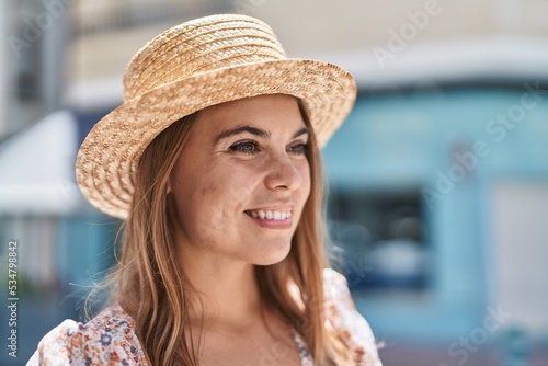 Young woman tourist wearing summer hat looking to the side at street