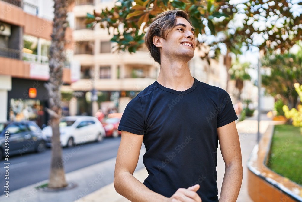 Young caucasian man smiling confident looking to the side at street Young caucasian man smiling confident looking to the side at street
