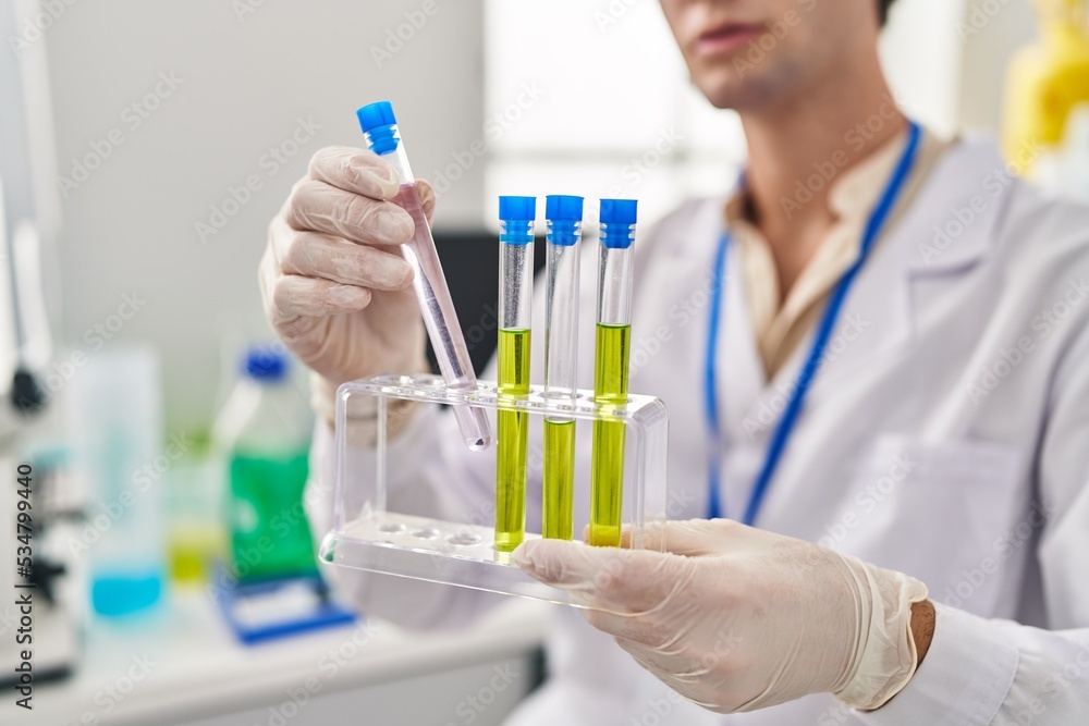 Young caucasian man scientist holding test tubes at laboratory Young caucasian man scientist holding test tubes at laboratory