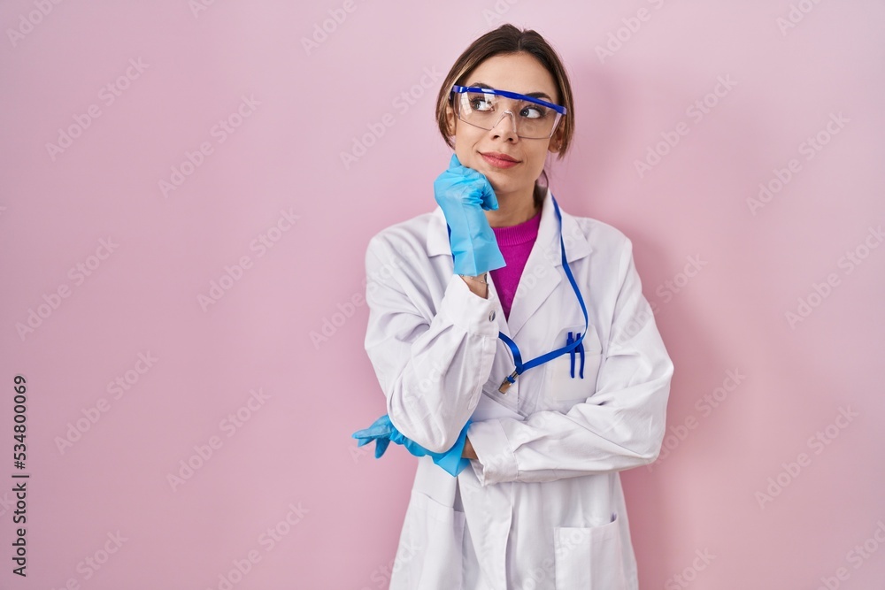 Hispanic woman wearing scientist uniform serious face thinking about question with hand on chin, thoughtful about confusing idea Hispanic woman wearing scientist uniform serious face thinking about question with hand on chin, thoughtful about confusing idea